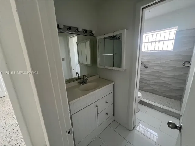 a bathroom with a sink a mirror and shower