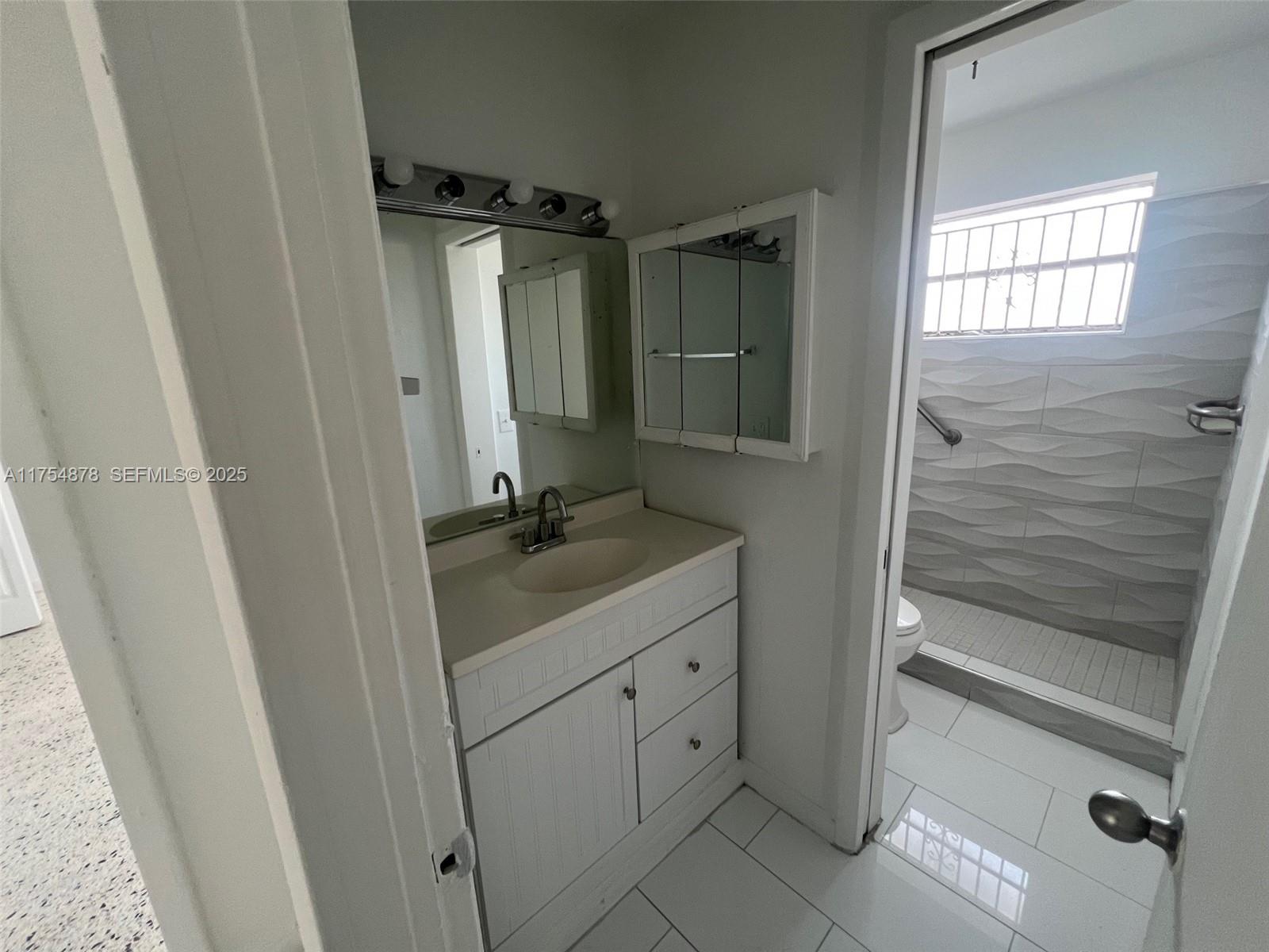 887 West 29th Street, Unit 2 Hialeah, FL 33012 - Photo 4 of 10 a bathroom with a sink a mirror and shower