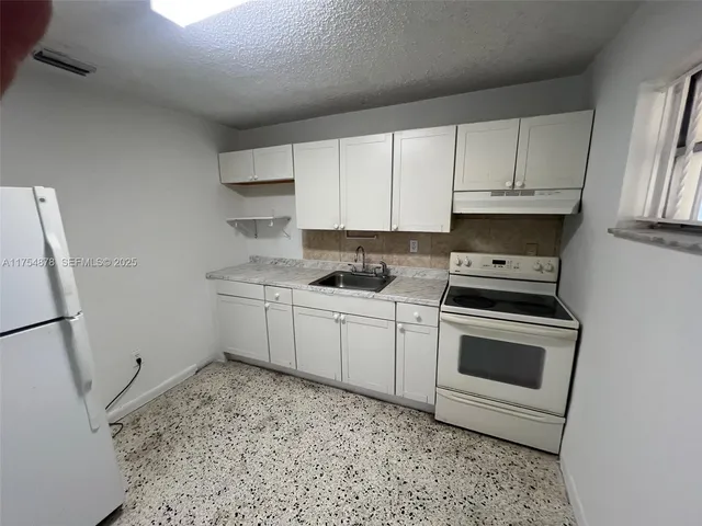 a kitchen with a sink stove and cabinets