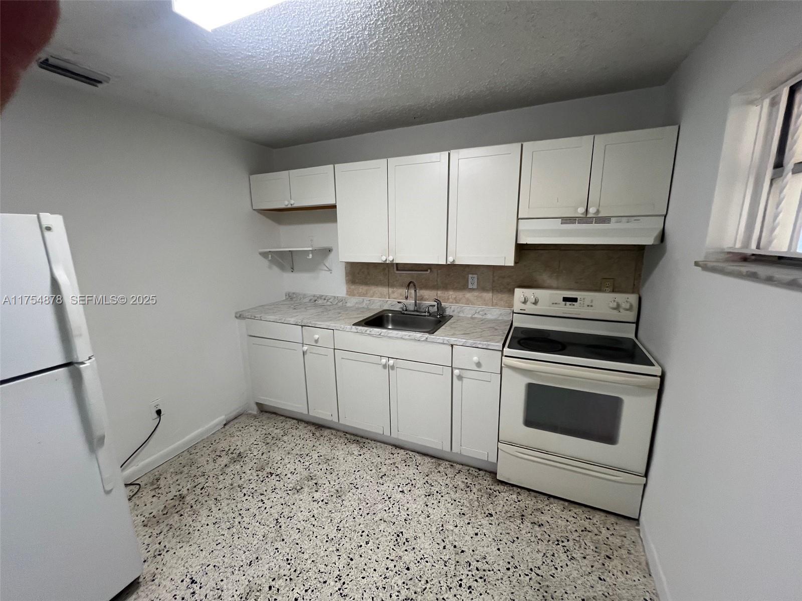 887 West 29th Street, Unit 2 Hialeah, FL 33012 - Photo 8 of 10 a kitchen with a sink stove and cabinets