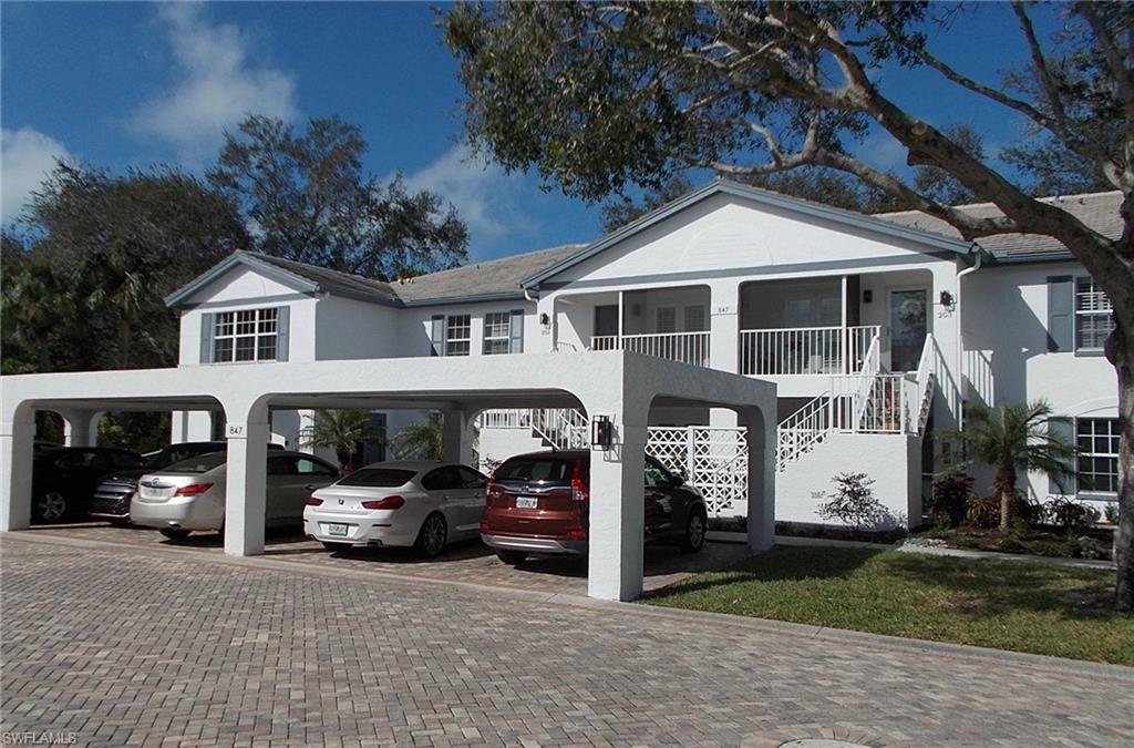 a car parked in front of a white house