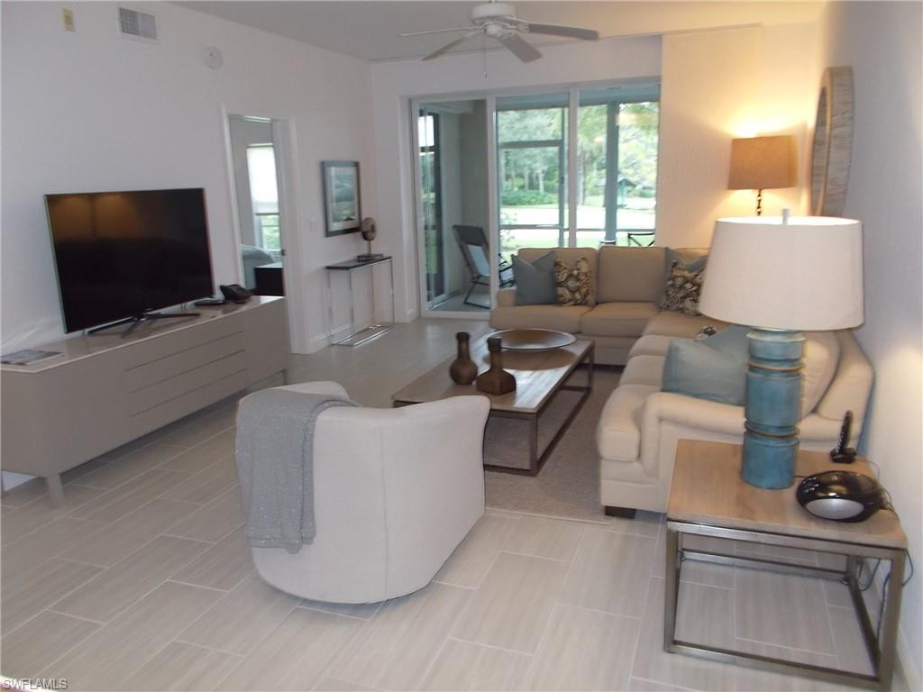 847 Tanbark Drive, Unit 101 Naples, FL 34108 - Photo 3 of 11 a living room with furniture and a flat screen tv