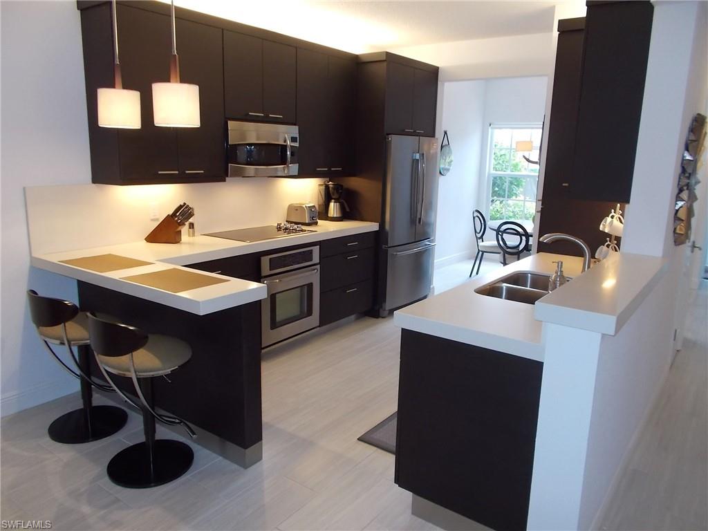 847 Tanbark Drive, Unit 101 Naples, FL 34108 - Photo 5 of 11 a kitchen with a sink cabinets and appliances