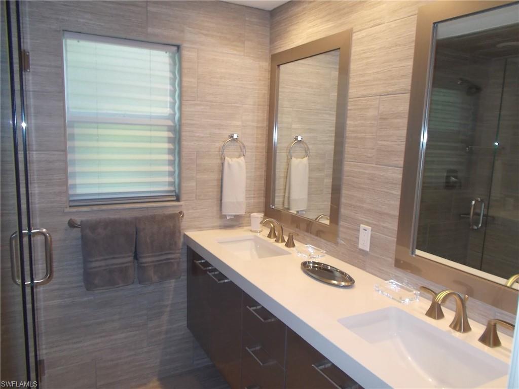 847 Tanbark Drive, Unit 101 Naples, FL 34108 - Photo 7 of 11 a bathroom with a sink and a mirror