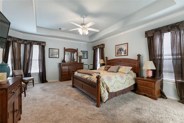 a bedroom with a large bed and a chandelier