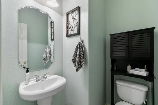 a bathroom with a toilet sink and mirror