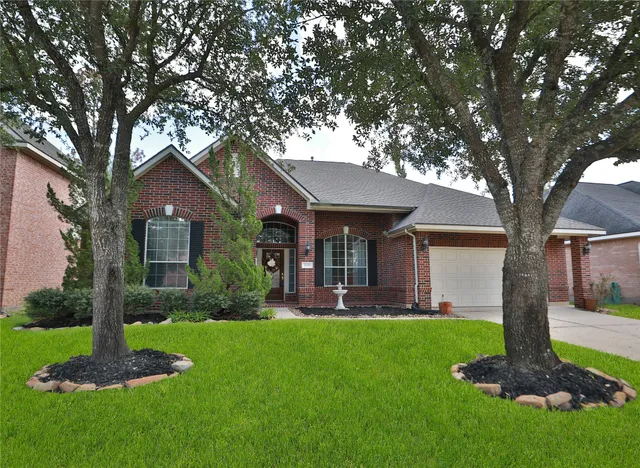 a front view of a house with a yard and tree