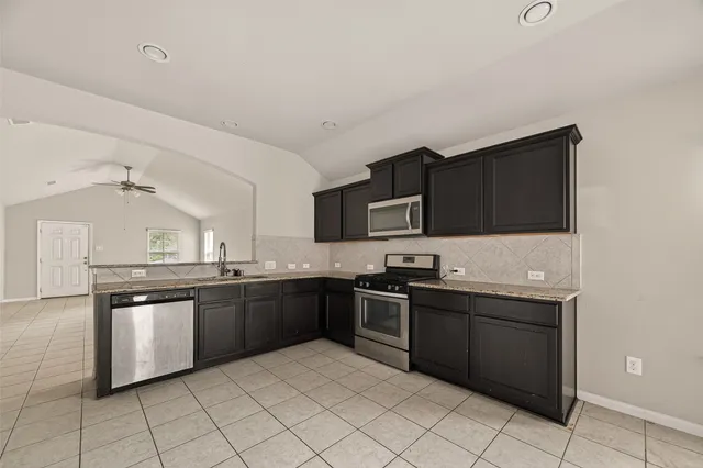 a kitchen with stainless steel appliances granite countertop a sink and stove top oven