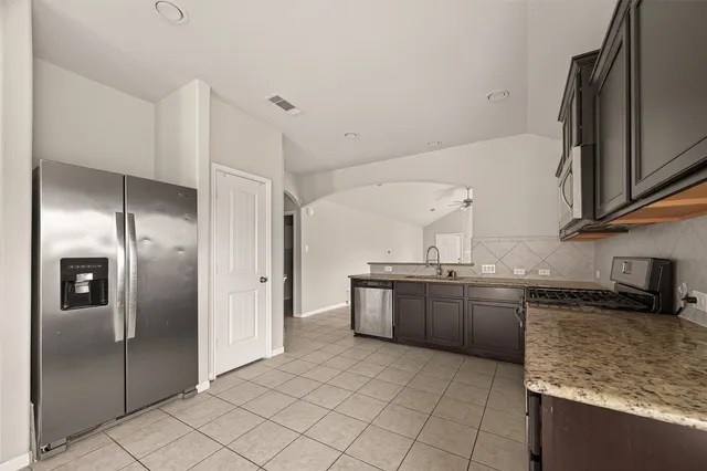 a kitchen with stainless steel appliances granite countertop a refrigerator and a sink