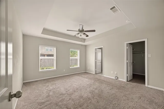 a view of a room with a windows and ceiling fan