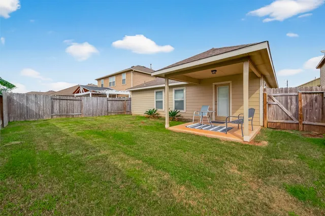 a view of a house with a yard and sitting area