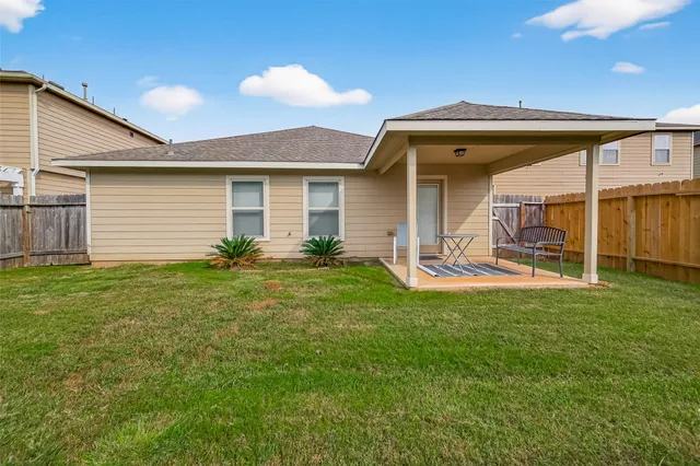 a backyard of a house with table and chairs