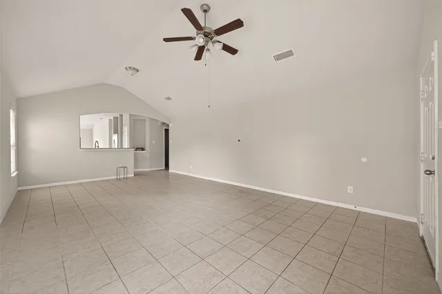 an empty room with fan and windows
