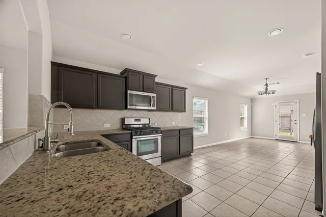 a kitchen with stainless steel appliances granite countertop a sink stove and refrigerator