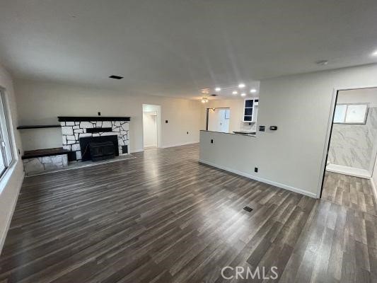 4797 Marklee Road Mariposa, CA 95338 - Photo 4 of 21 an empty room with wooden floor a fireplace and windows
