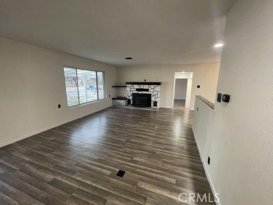 4797 Marklee Road Mariposa, CA 95338 - Photo 6 of 21 an empty room with wooden floor and fireplace