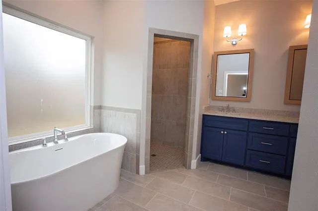 a bathroom with a tub sink and mirror