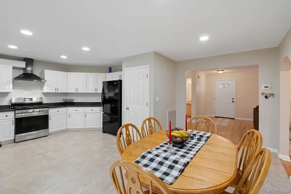 a kitchen with stainless steel appliances kitchen island granite countertop a stove a sink a refrigerator and cabinets