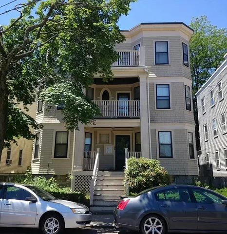 a front view of a house with car parked