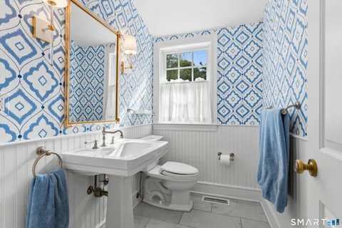 a bathroom with a sink and mirror with toilet