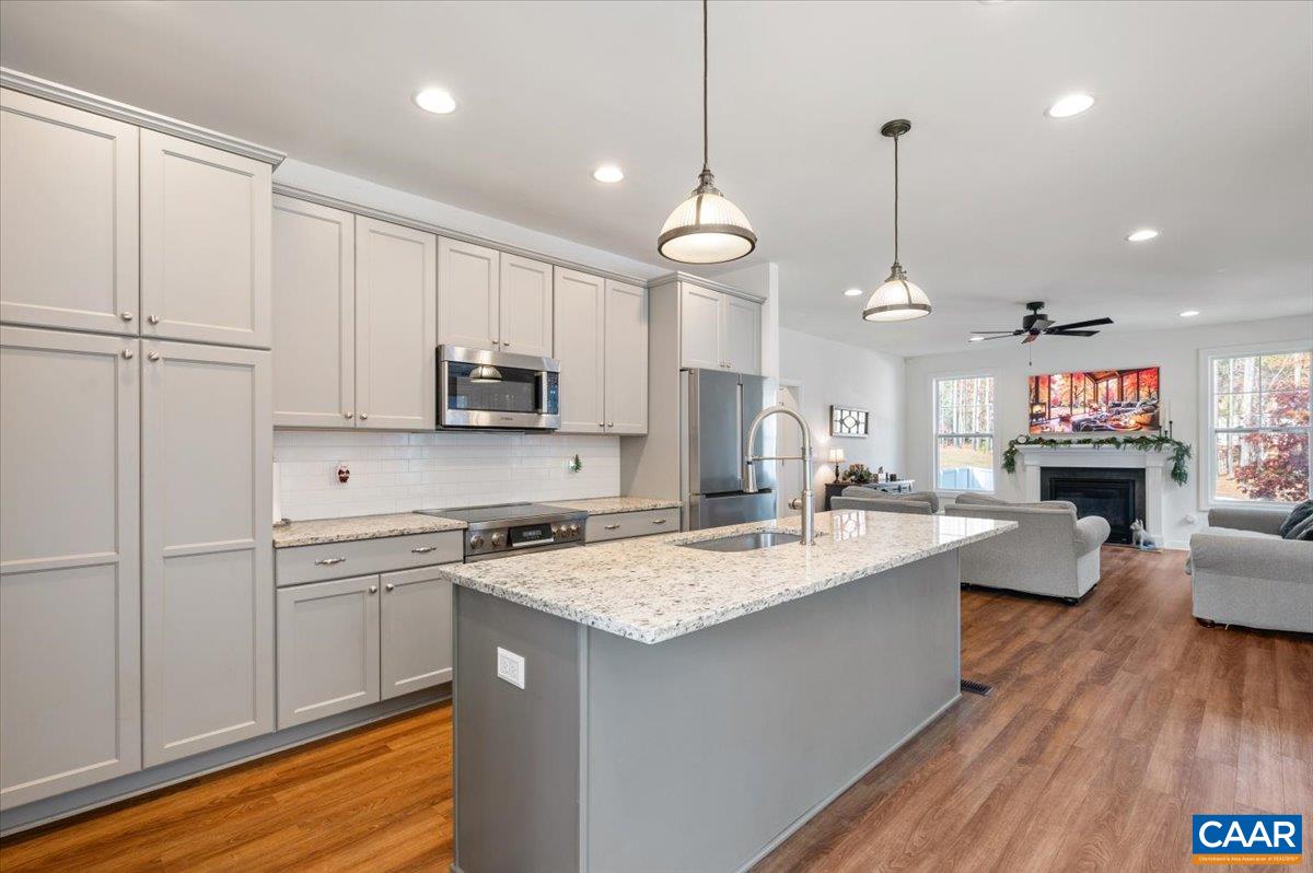 481 Country Creek Way Palmyra, VA 22963 - Photo 4 of 66 a large kitchen with kitchen island a stove a sink a center island and wooden floor