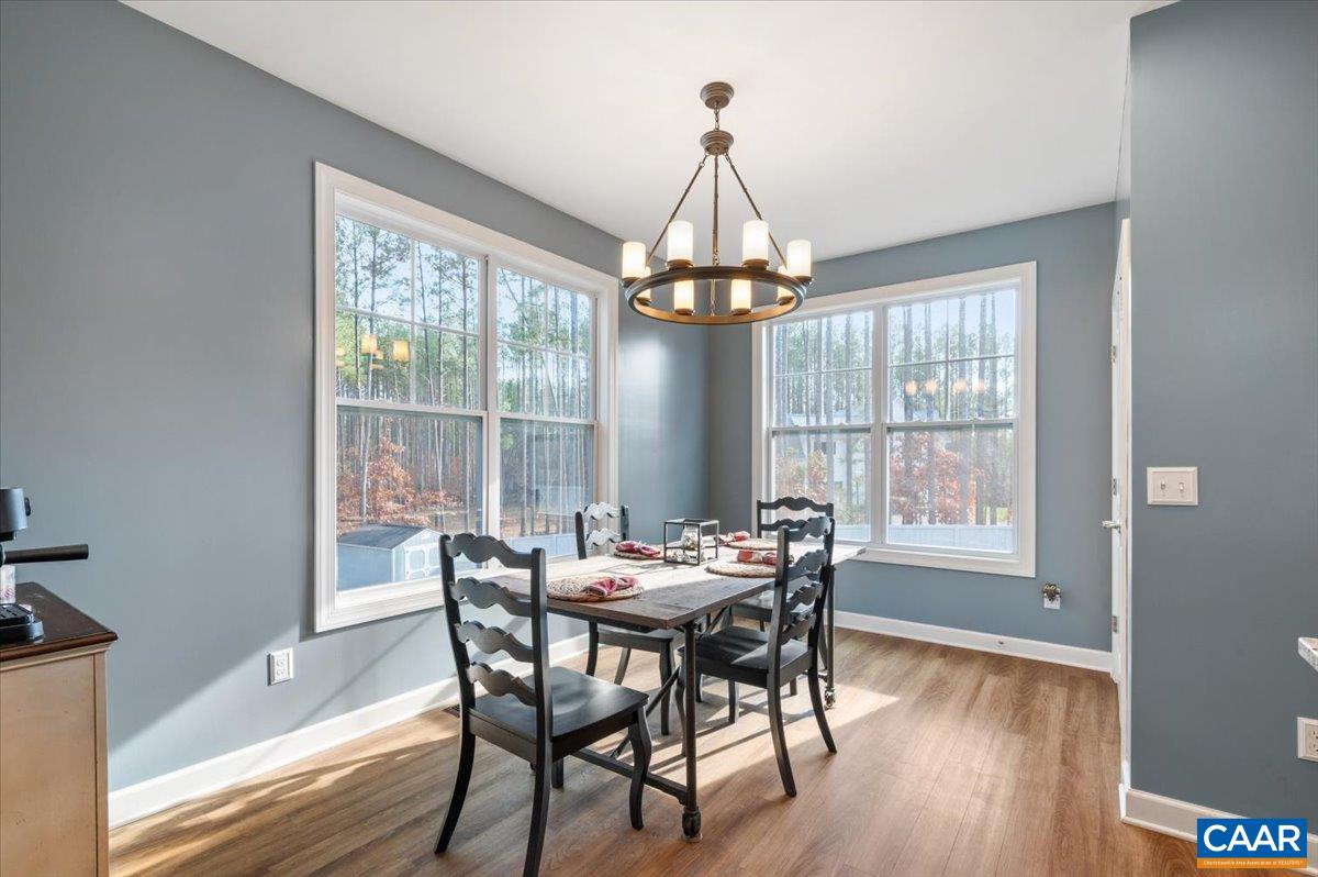 481 Country Creek Way Palmyra, VA 22963 - Photo 8 of 66 a dining room with furniture a chandelier and wooden floor