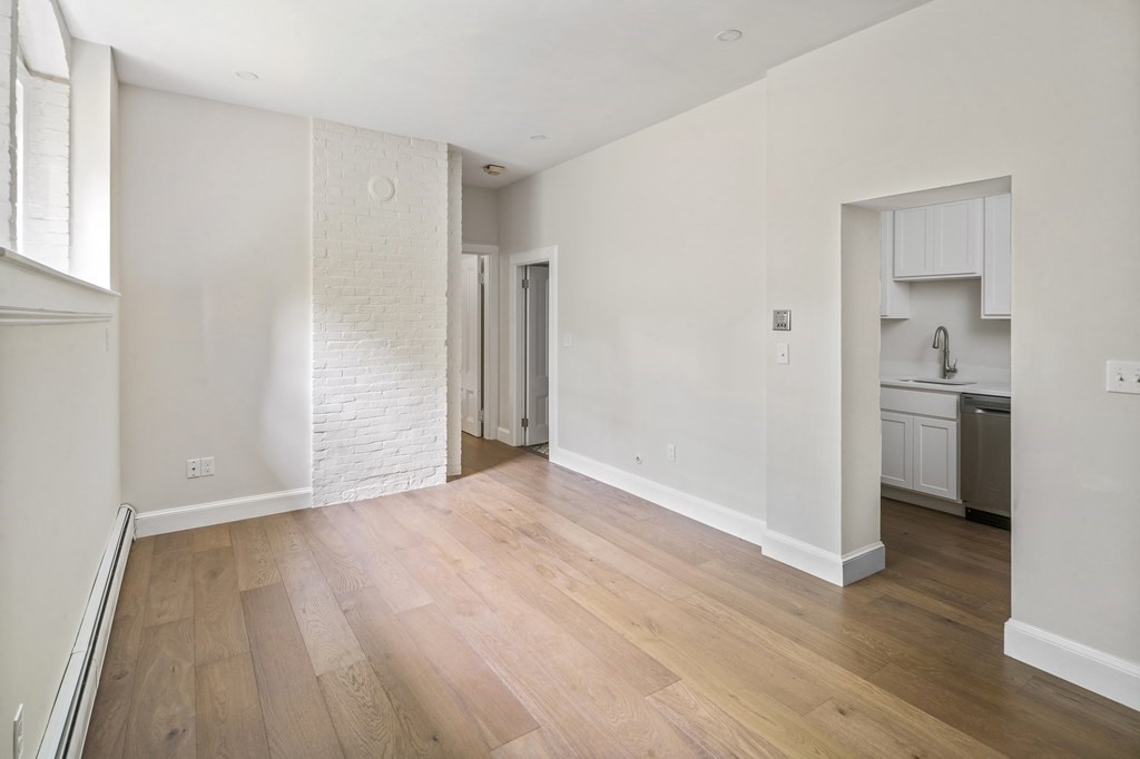 1000 Centre Street, Unit 3 Boston, MA 02130 - Photo 3 of 14 a view of empty room with wooden floor and kitchen