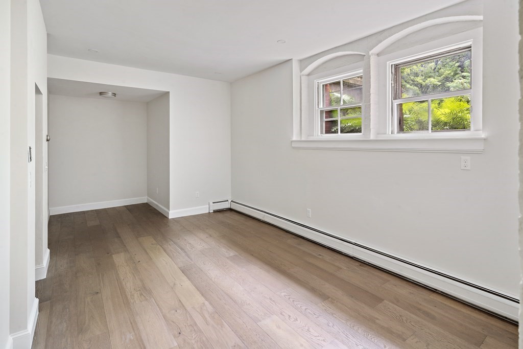 1000 Centre Street, Unit 3 Boston, MA 02130 - Photo 5 of 14 a view of an empty room with wooden floor and a window