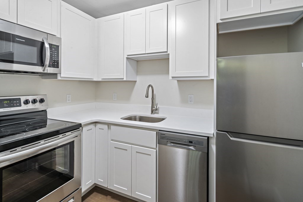 1000 Centre Street, Unit 3 Boston, MA 02130 - Photo 8 of 14 a kitchen with stainless steel appliances white cabinets and a stove top oven