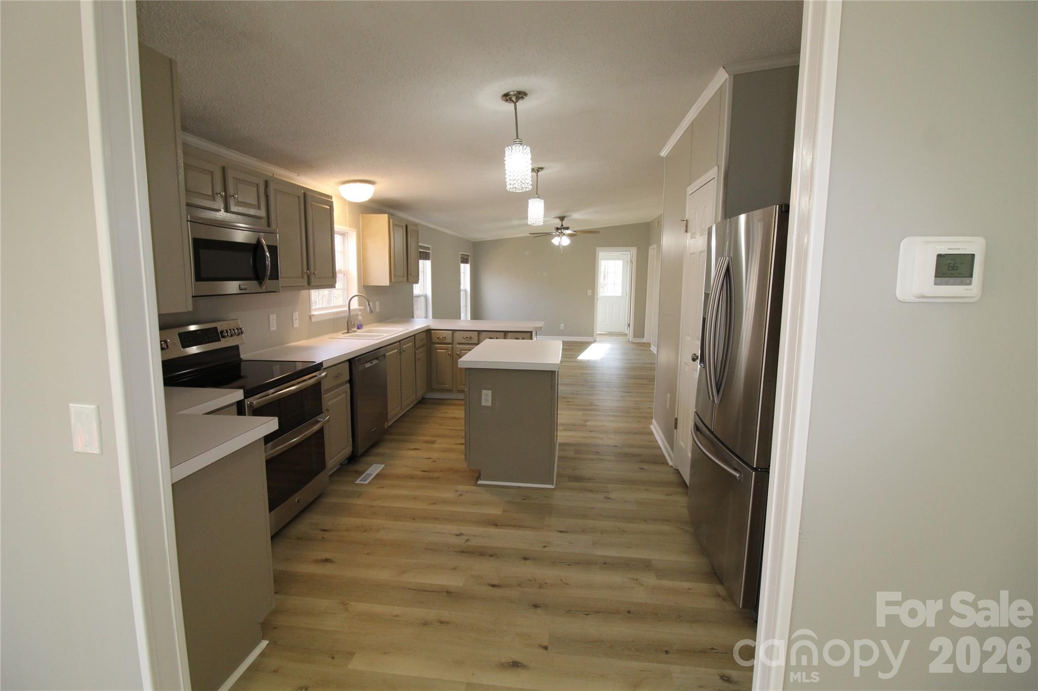410 Johnstone Road Cleveland, NC 27013 - Photo 21 of 43 a large kitchen with granite countertop a stove top oven a sink a counter space and cabinets