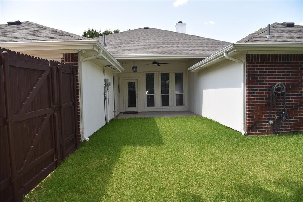 1526 Pebblestone Court Allen, TX 75002 - Photo 27 of 28 Gated backyard area with a verdant lawn, featuring a covered patio, ceiling fan, and French-style glass doors