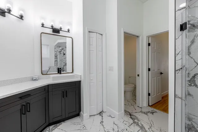 a bathroom with a mirror a sink and glass door