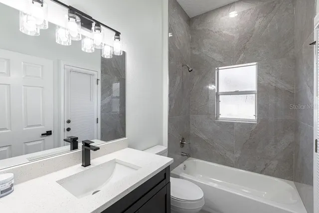 a bathroom with a bathtub a sink a toilet a mirror and shower