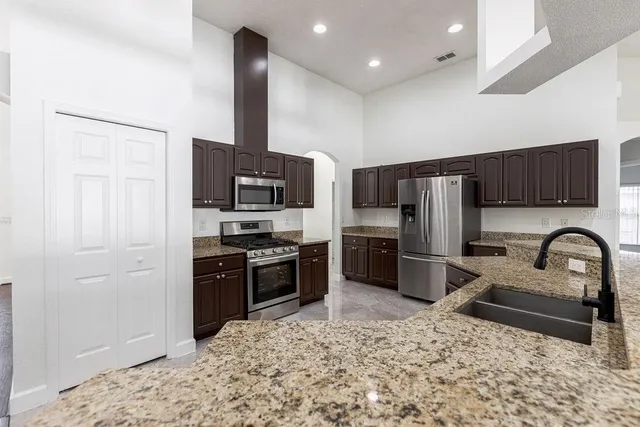 a kitchen with a refrigerator sink and wooden cabinets