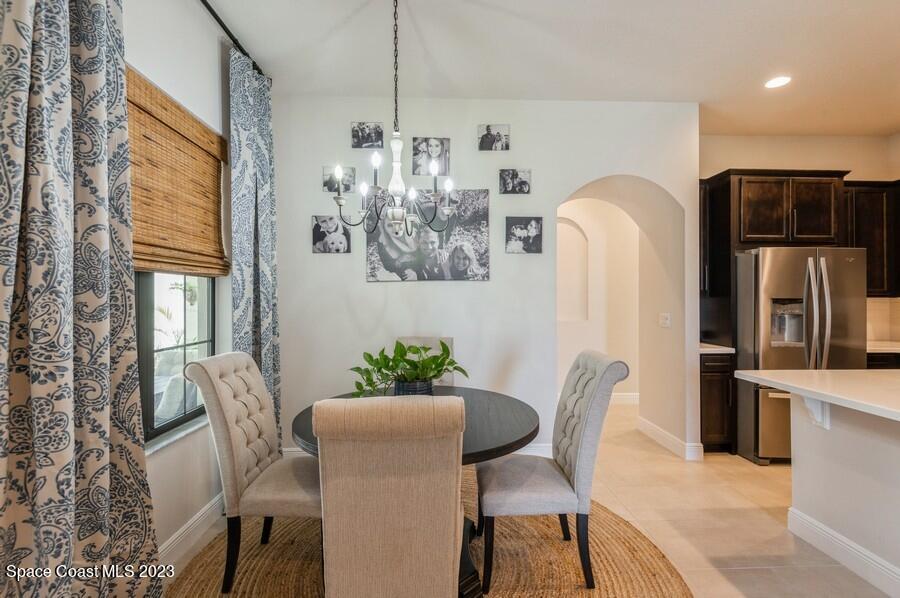 8072 Rungsted Lane Melbourne, FL 32940 - Photo 12 of 59 a dining room with furniture a chandelier and window