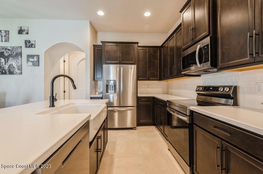 8072 Rungsted Lane Melbourne, FL 32940 - Photo 17 of 59 a kitchen with stainless steel appliances a sink stove and refrigerator