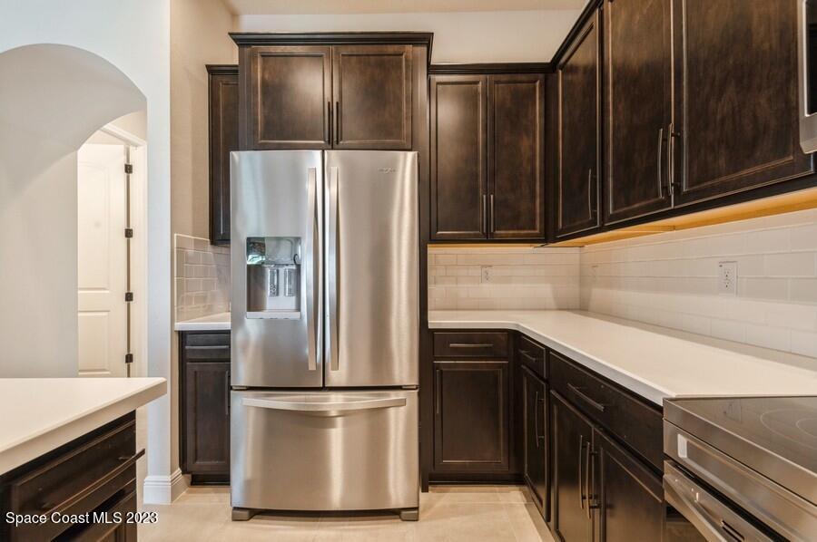 8072 Rungsted Lane Melbourne, FL 32940 - Photo 19 of 59 a kitchen with a refrigerator sink and cabinets