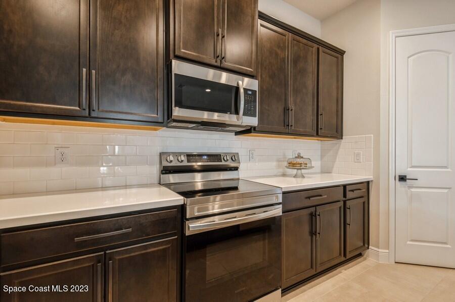 8072 Rungsted Lane Melbourne, FL 32940 - Photo 20 of 59 a kitchen with a sink and stainless steel appliances