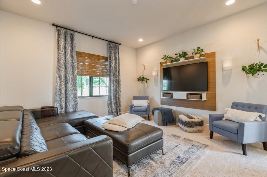 8072 Rungsted Lane Melbourne, FL 32940 - Photo 21 of 59 a living room with furniture and a flat screen tv