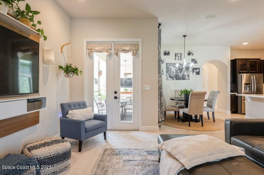 8072 Rungsted Lane Melbourne, FL 32940 - Photo 24 of 59 a living room with furniture wooden floor and a chandelier