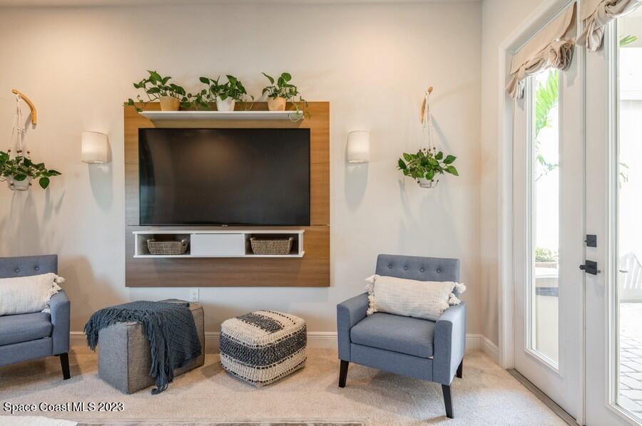 8072 Rungsted Lane Melbourne, FL 32940 - Photo 26 of 59 a living room with furniture a flat screen tv and a potted plant