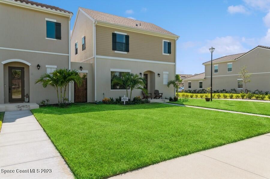 8072 Rungsted Lane Melbourne, FL 32940 - Photo 3 of 59 a front view of a house with a garden and plants