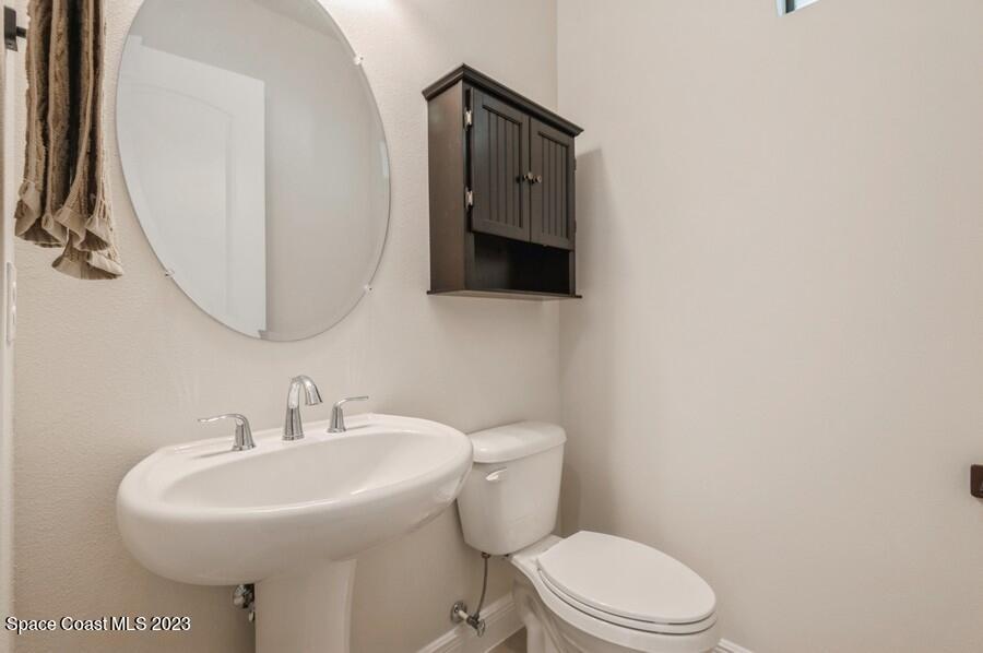 8072 Rungsted Lane Melbourne, FL 32940 - Photo 34 of 59 a bathroom with a toilet sink and mirror