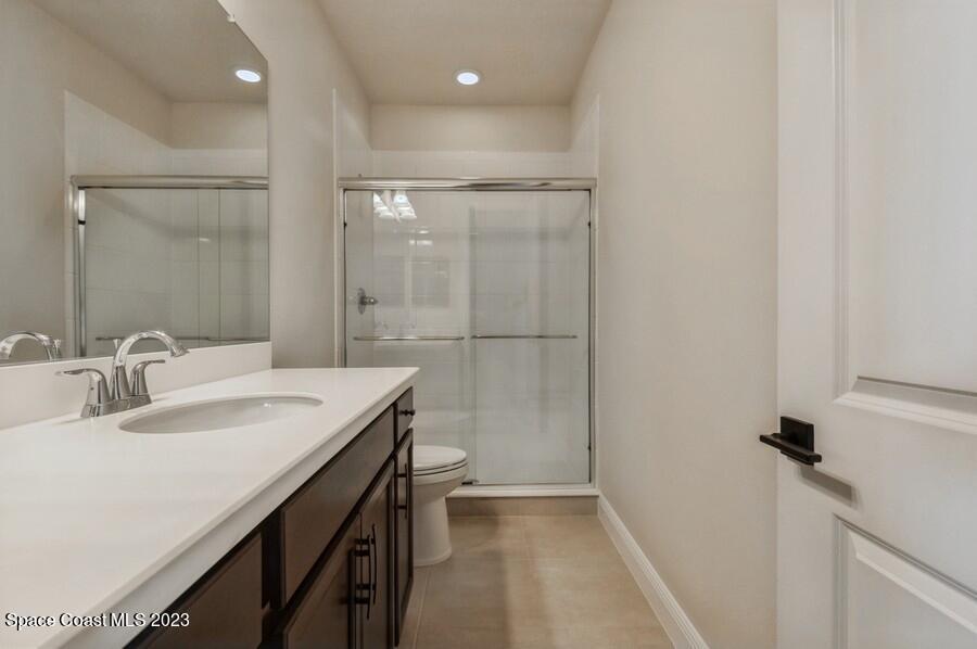 8072 Rungsted Lane Melbourne, FL 32940 - Photo 40 of 59 a bathroom with a sink a mirror and a shower