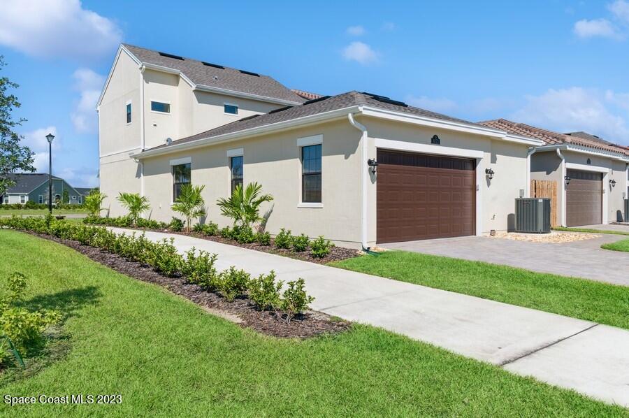 8072 Rungsted Lane Melbourne, FL 32940 - Photo 4 of 59 a front view of a house with a yard and garage