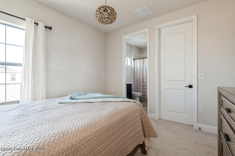 8072 Rungsted Lane Melbourne, FL 32940 - Photo 49 of 59 a bedroom with a bed and a large mirror