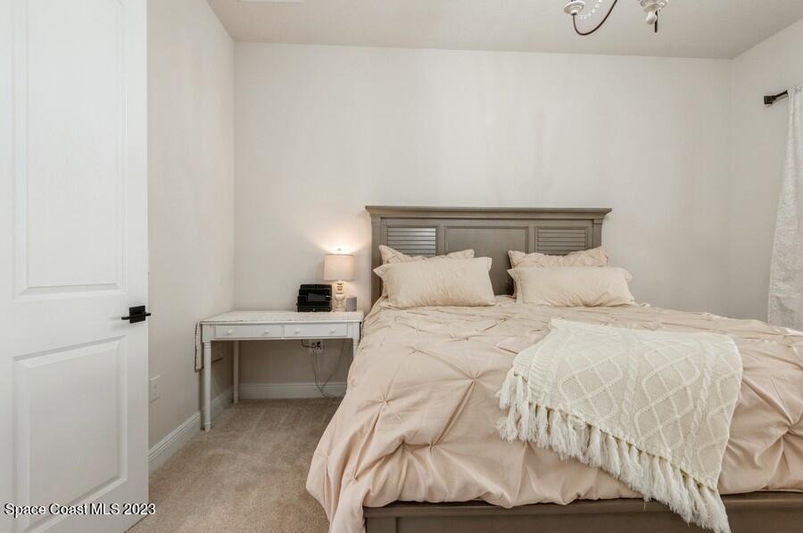 8072 Rungsted Lane Melbourne, FL 32940 - Photo 52 of 59 a bedroom with a bed and a table