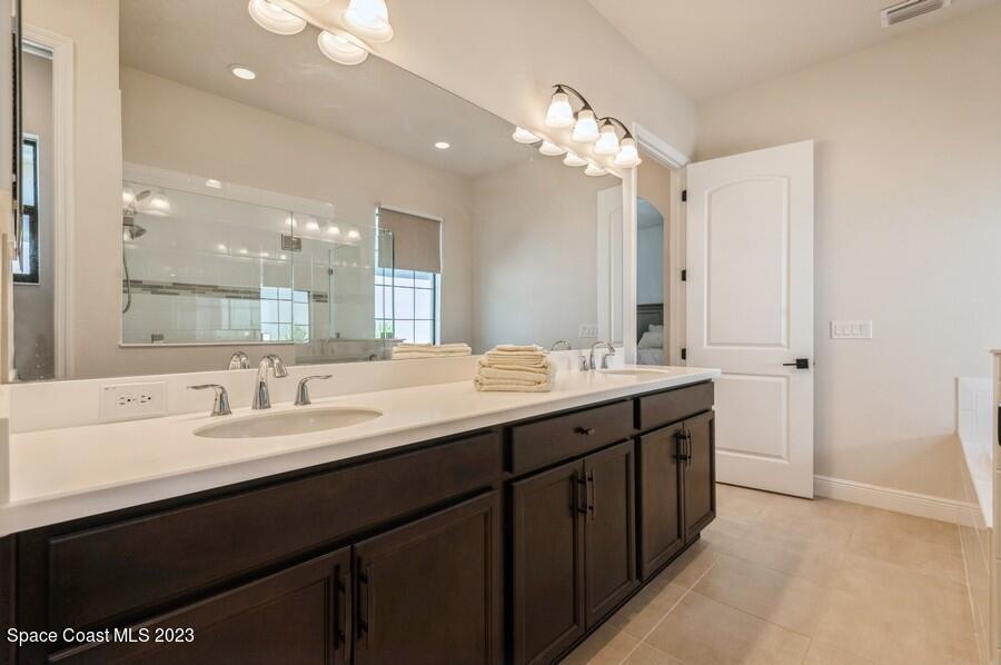 8072 Rungsted Lane Melbourne, FL 32940 - Photo 58 of 59 a bathroom with a double vanity sink mirror and double