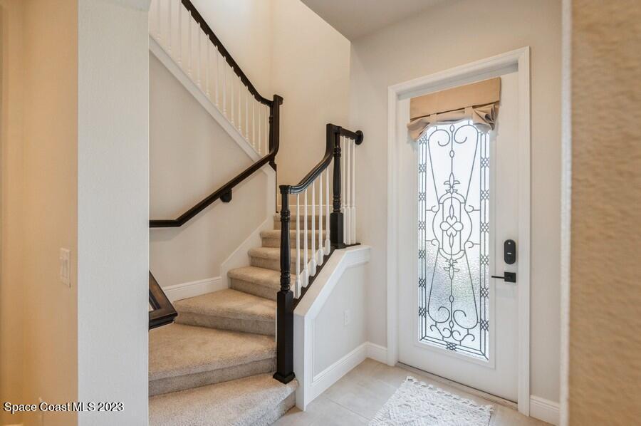 8072 Rungsted Lane Melbourne, FL 32940 - Photo 8 of 59 a view of entryway with wooden floor and stairs