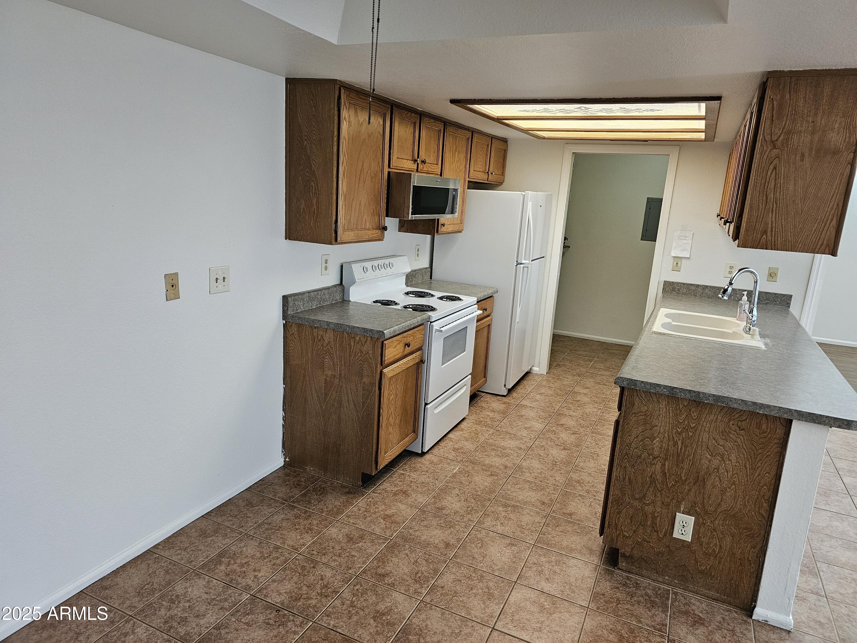 633 West Southern Avenue, Unit 1118 Tempe, AZ 85282 - Photo 3 of 12 a kitchen with stainless steel appliances granite countertop a sink stove and refrigerator